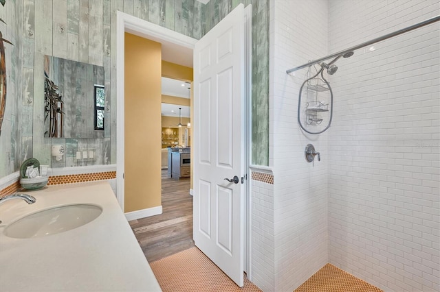 bathroom with vanity, a tile shower, and wood finished floors
