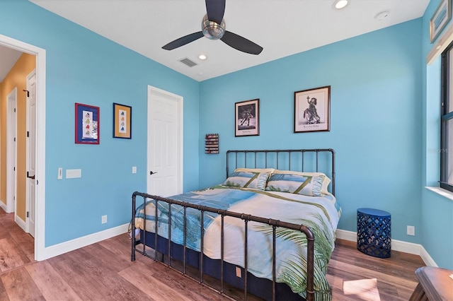 bedroom featuring baseboards, visible vents, and wood finished floors