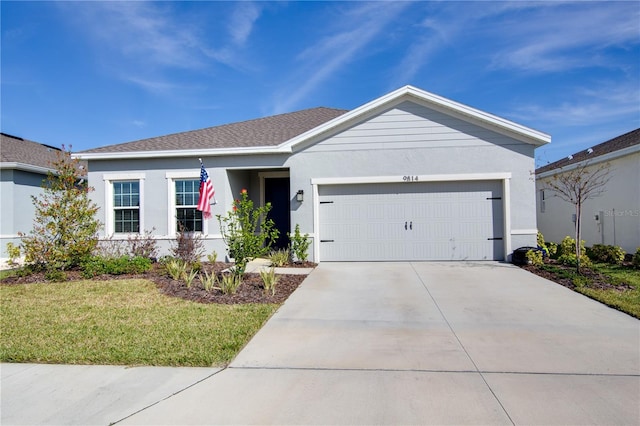 single story home with a garage, a shingled roof, concrete driveway, stucco siding, and a front lawn