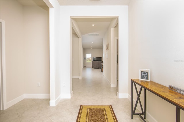 hallway featuring light tile patterned floors, recessed lighting, visible vents, and baseboards