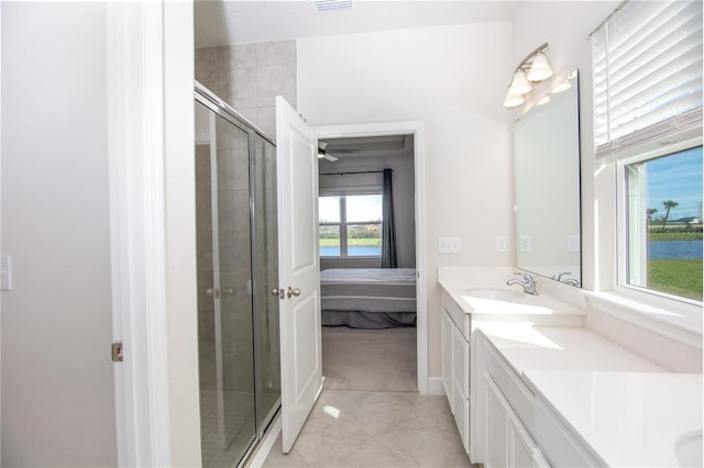 bathroom featuring tile patterned flooring, plenty of natural light, and a shower with shower door