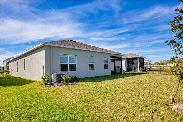 back of house with a yard, central air condition unit, and a sunroom