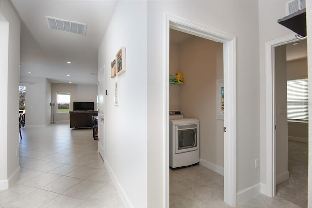 hallway featuring washer / clothes dryer and light tile patterned floors