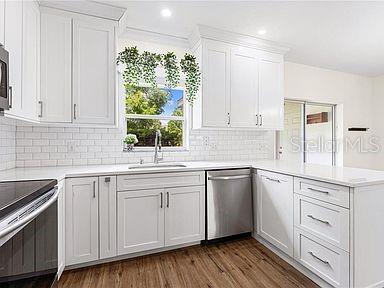 kitchen featuring white cabinets, stainless steel appliances, and light countertops