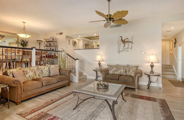 living room featuring ceiling fan and light hardwood / wood-style flooring