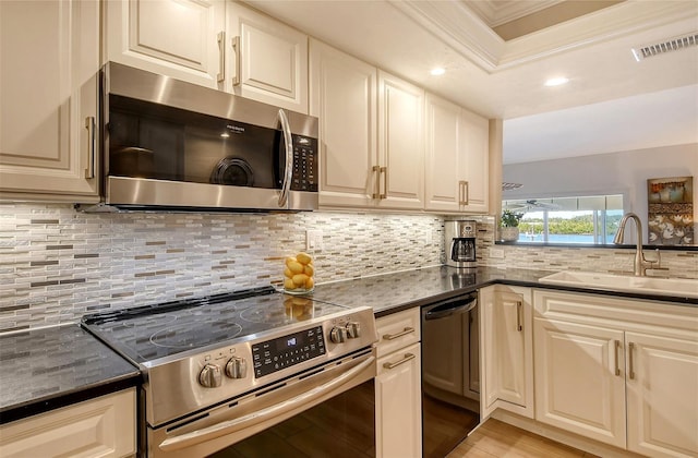 kitchen featuring backsplash, sink, stainless steel appliances, and ornamental molding