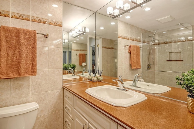 bathroom featuring vanity, toilet, tile walls, and walk in shower