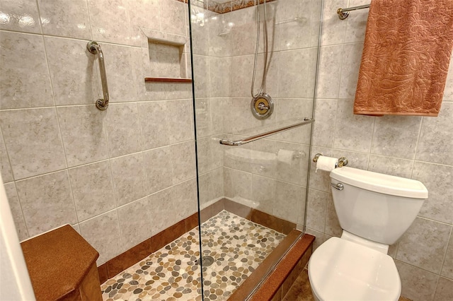 bathroom featuring tiled shower and toilet