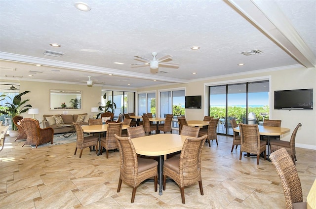 dining space featuring a textured ceiling, ceiling fan, and crown molding