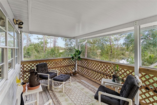 sunroom featuring a water view