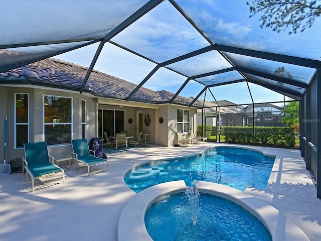 view of pool featuring a lanai, a patio area, and an in ground hot tub