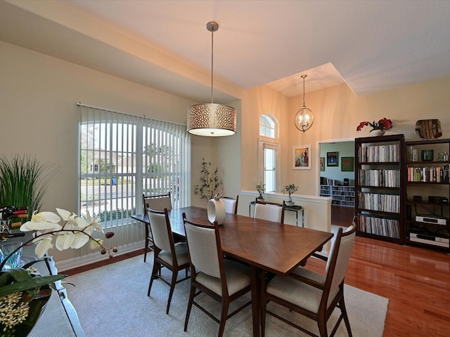 dining room with hardwood / wood-style floors and an inviting chandelier