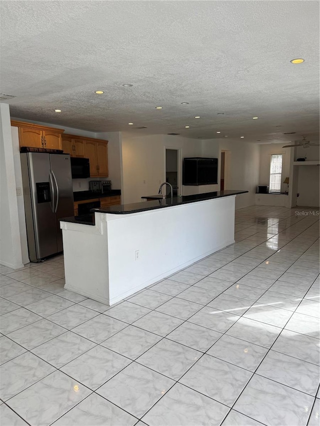 kitchen with sink and stainless steel refrigerator with ice dispenser