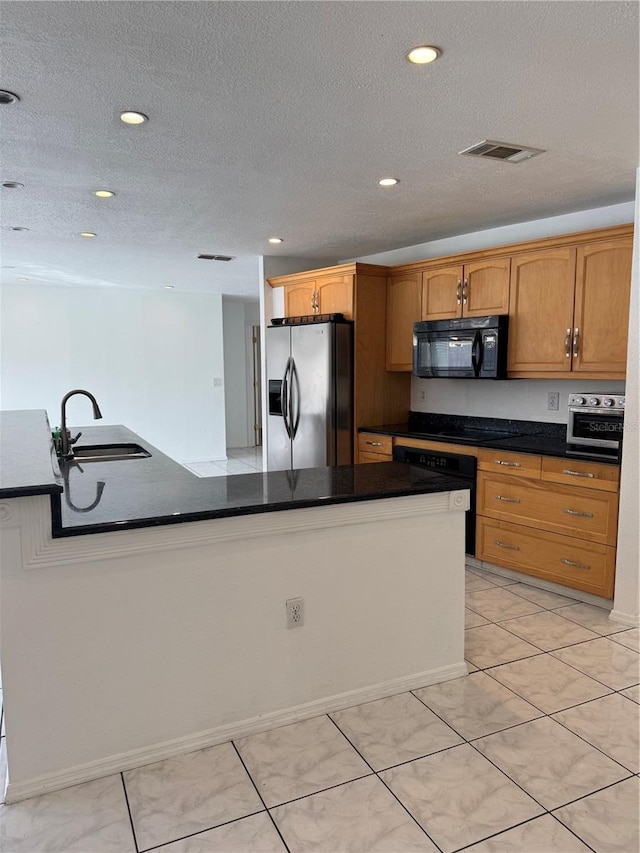 kitchen featuring sink, light tile patterned flooring, black appliances, and a textured ceiling