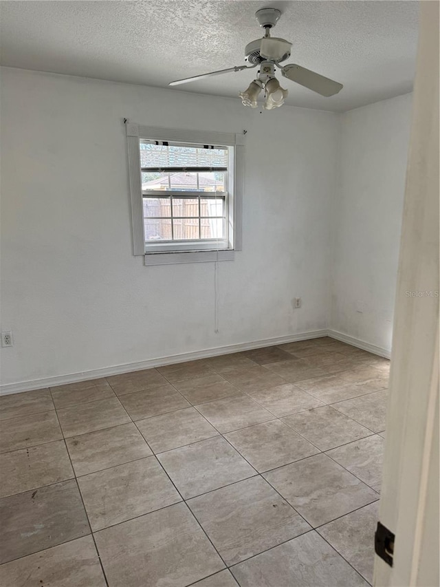 tiled spare room with a textured ceiling and ceiling fan