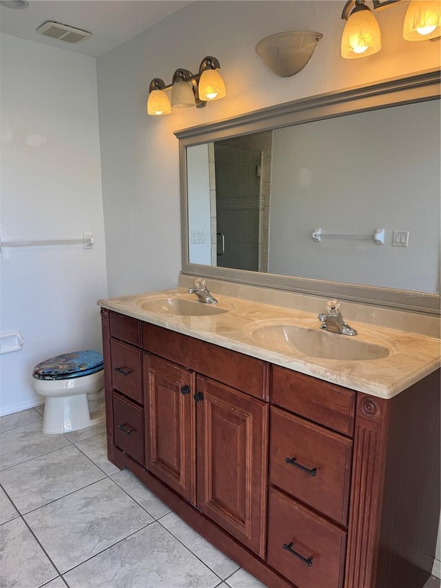 bathroom featuring tile patterned floors, vanity, toilet, and a shower with door