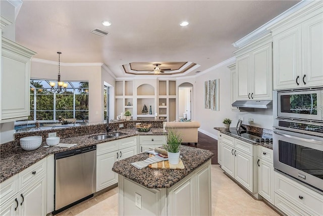 kitchen with appliances with stainless steel finishes, dark stone countertops, white cabinetry, and sink