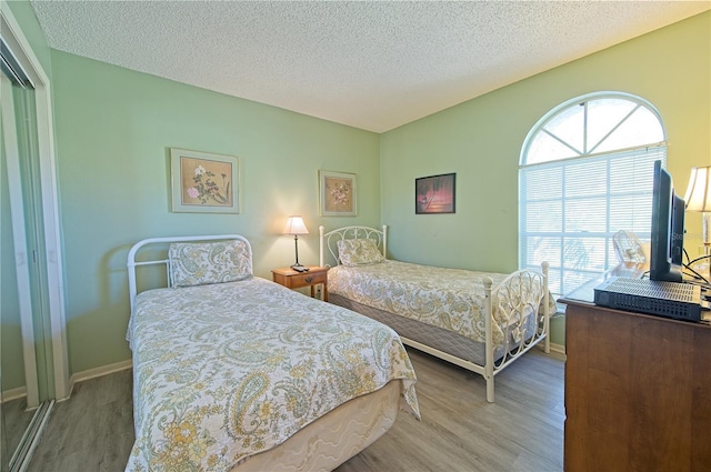 bedroom with hardwood / wood-style floors and a textured ceiling