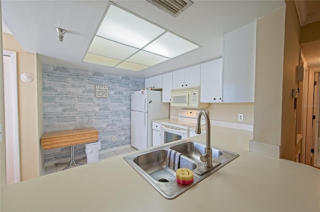 kitchen featuring kitchen peninsula, white cabinetry, sink, and white appliances