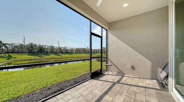 unfurnished sunroom featuring a water view