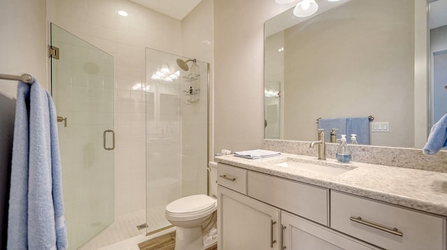 bathroom with toilet, an enclosed shower, and vanity