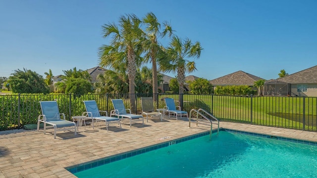 view of pool with a patio area and a yard