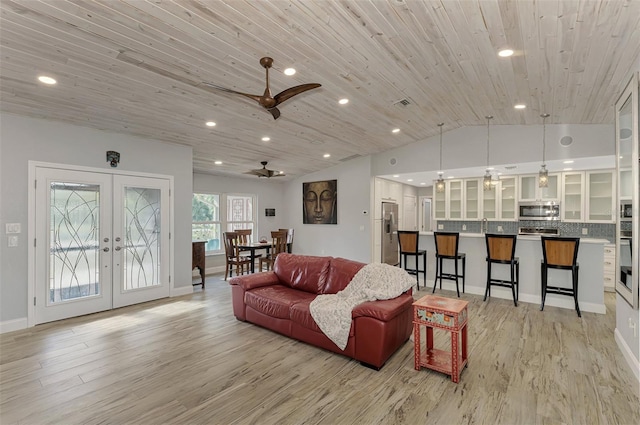 living room with ceiling fan, light hardwood / wood-style floors, wooden ceiling, french doors, and vaulted ceiling