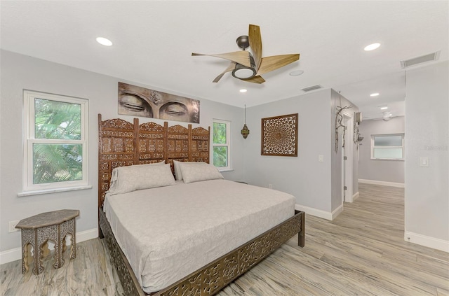 bedroom featuring light wood-type flooring, ceiling fan, and multiple windows