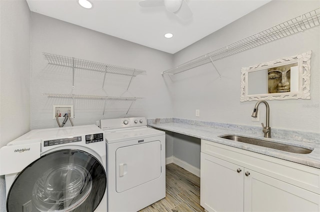 laundry area featuring sink, light wood-type flooring, ceiling fan, and washing machine and clothes dryer