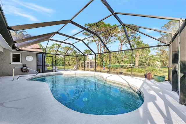 view of swimming pool with glass enclosure and a patio