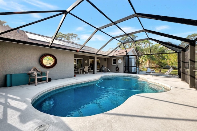 view of swimming pool with a patio area and a lanai