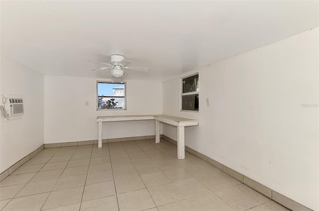 basement featuring a wall mounted air conditioner and ceiling fan