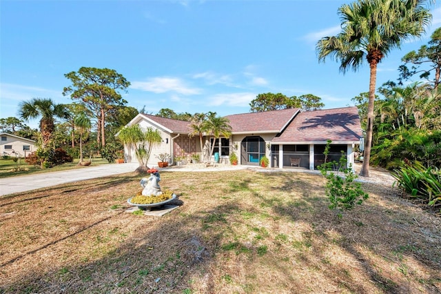 ranch-style home with a front yard and a sunroom