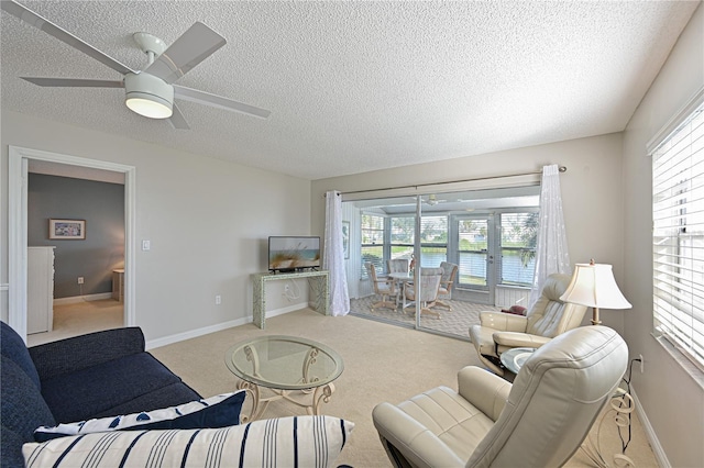 carpeted living room featuring a textured ceiling, ceiling fan, and a healthy amount of sunlight