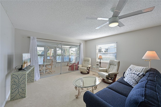 living room featuring carpet, a textured ceiling, plenty of natural light, and ceiling fan