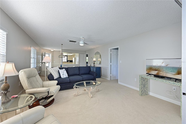 carpeted living room featuring ceiling fan and a textured ceiling