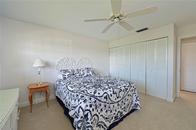 carpeted bedroom featuring a textured ceiling, a closet, and ceiling fan