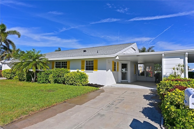 ranch-style home with a front yard, stucco siding, driveway, and a carport