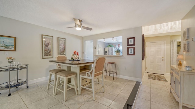 dining room featuring ceiling fan, light tile patterned flooring, and a textured ceiling