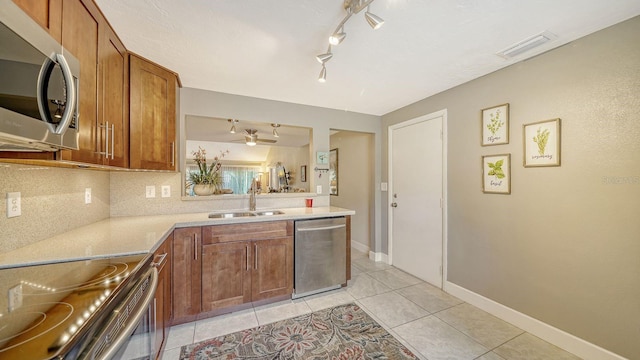 kitchen with ceiling fan, sink, stainless steel appliances, decorative backsplash, and light tile patterned flooring