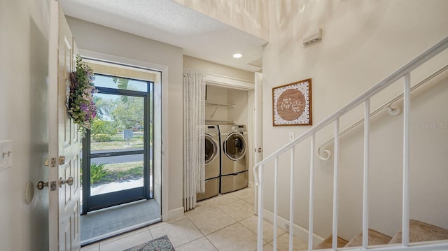 clothes washing area featuring separate washer and dryer and light tile patterned floors