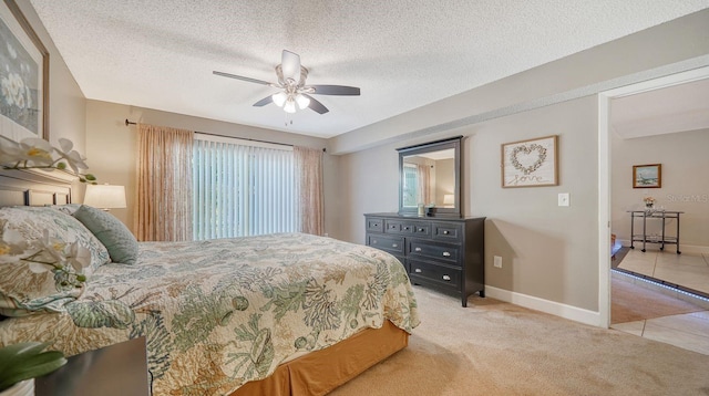 bedroom featuring a textured ceiling, ceiling fan, and light carpet