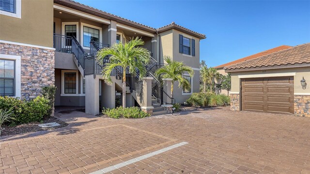 mediterranean / spanish-style house with stone siding, stairway, and stucco siding