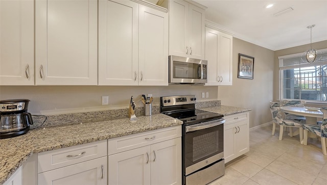 kitchen with light stone countertops, light tile patterned floors, appliances with stainless steel finishes, and white cabinets