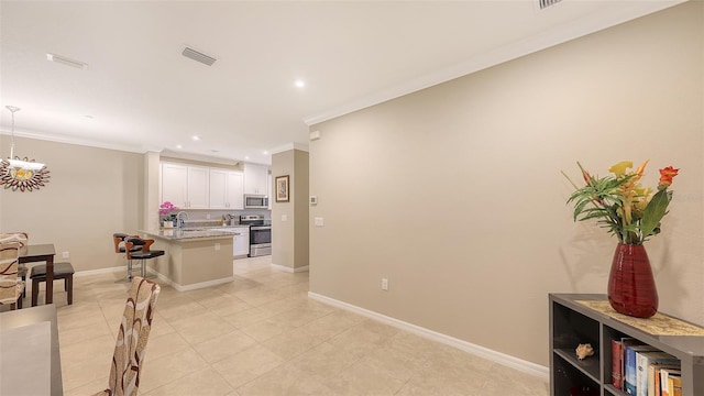 kitchen featuring crown molding, stainless steel appliances, visible vents, white cabinets, and a kitchen bar