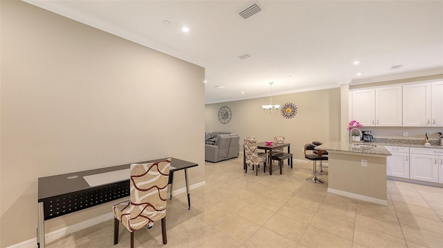 kitchen featuring a breakfast bar, crown molding, light tile patterned floors, visible vents, and white cabinetry