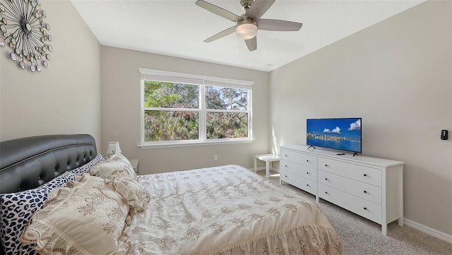 bedroom featuring light colored carpet, ceiling fan, and baseboards