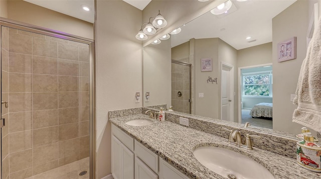 ensuite bathroom with double vanity, a stall shower, a sink, and connected bathroom