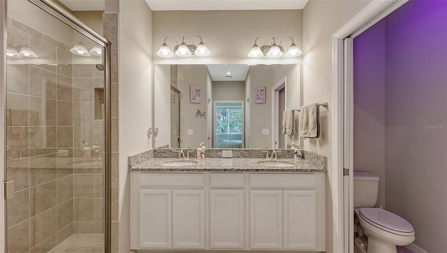 full bathroom featuring double vanity, a sink, toilet, and a shower stall