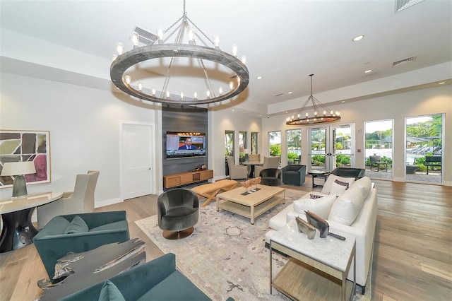 living room with visible vents, wood finished floors, french doors, a notable chandelier, and recessed lighting